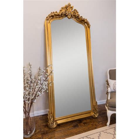 A wall mounted floor mirror propped up against a wall will draw the eye upwards, making the room look even larger. Blenheim Gold Crown Arched Full Length Floor Mirror | Chairish