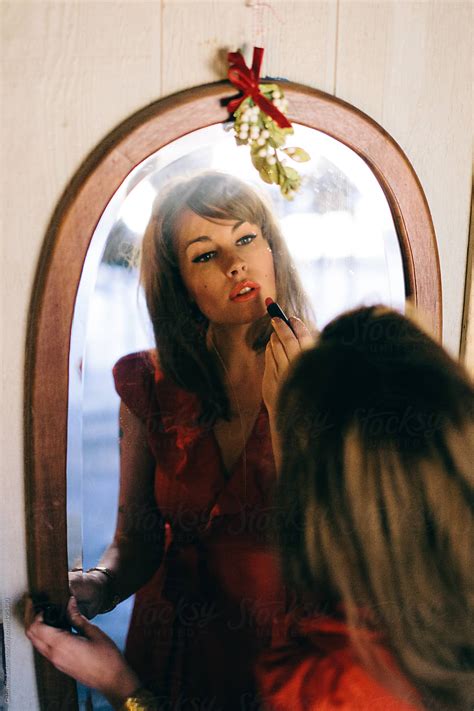 Woman Putting On Lipstick In The Mirror By Gabrielle Lutze