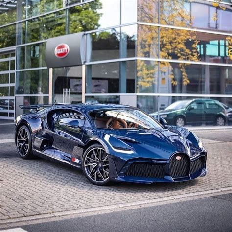 A Blue Bugatti Is Parked In Front Of A Building With Cars Behind It