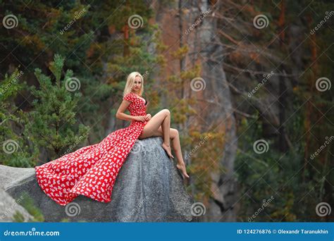Beautiful Woman In The Red Dress Posing On The Mountain Stock Photo