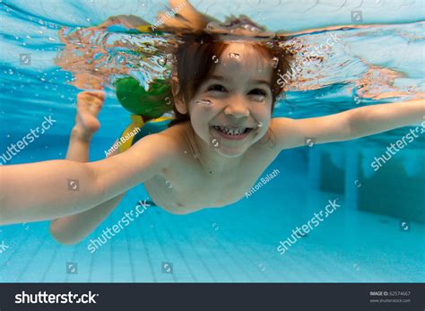 The Little Girl In The Water Park Swimming Underwater And Smiling 스톡 사진