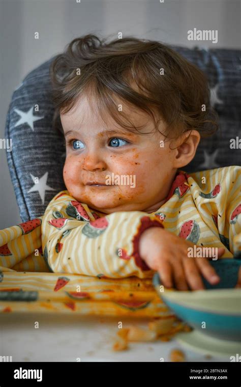 Baby Eating Food With A Messy Face Stock Photo Alamy