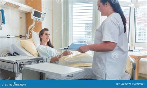 Nurse Bringing Woman Patient Meal On The Hospital Bed Royalty Free