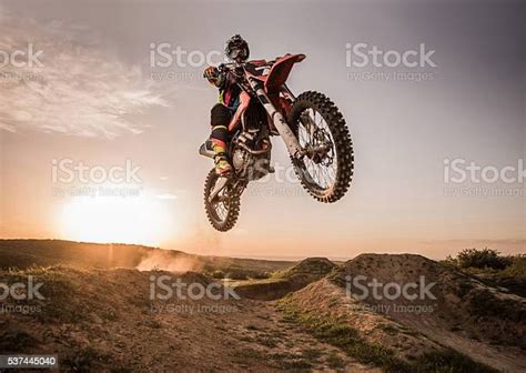 Motocross Rider Performing High Jump At Sunset Stock Photo Download