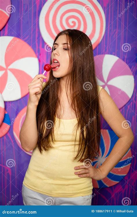 Beautiful Woman With A Lollipop In Her Hands On A Background Of