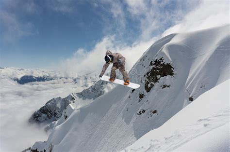 Extreme Winter Sport Snowboarder Jumping In Snowy Mountains Stock