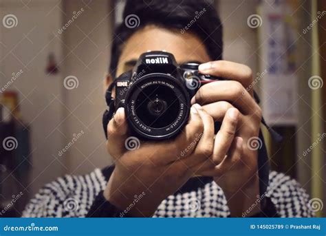 A Person Taking Photo From His Nikon Dslr Camera Facing Camera