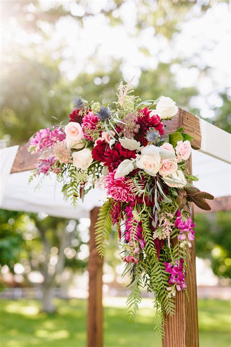 Rustic Chuppah With Bright Pink Red And Blush Flowers
