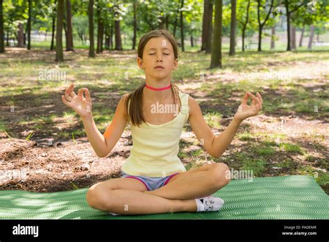 Niña Feliz Y Meditar Sobre La Práctica Del Yoga En El Parque Yoga Kid