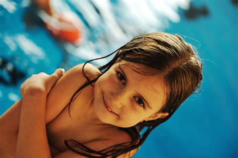 Little Cute Girl In Blue Water Of The Swimming Pool Royalty Free Stock