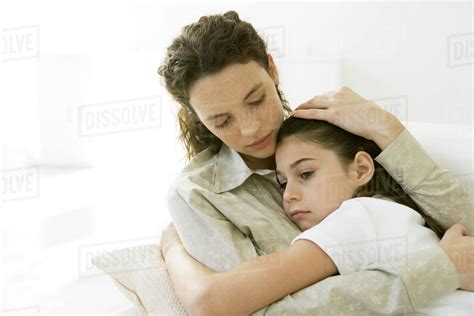 Mother And Daughter Hugging Each Other Girl Frowning Stock Photo