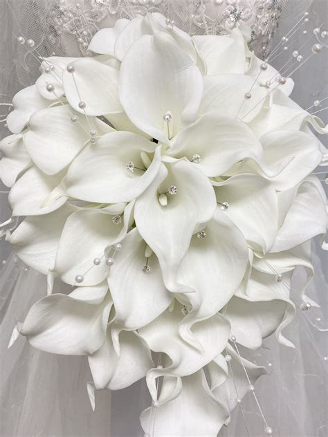 A Bridal Bouquet With White Flowers And Pearls