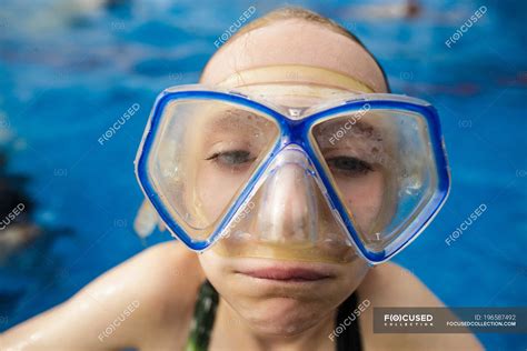 a girl in swimming pool wearing goggles and making a funny face — brunette adventure stock