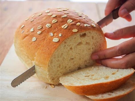 Premium Photo Female Hand Using A Bread Knife To Slice Homemade Bread