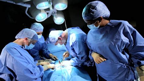 Doctor Wearing Protective Clothing Performing Surgery Using Sterilised