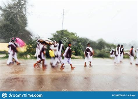 Motion Blur Of Indian Students Walking In The Rain On The Road They