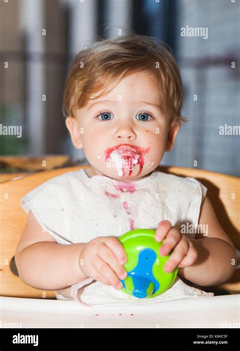 Happy Messy Baby With Food On Her Face After Eating Dessert Stock Photo