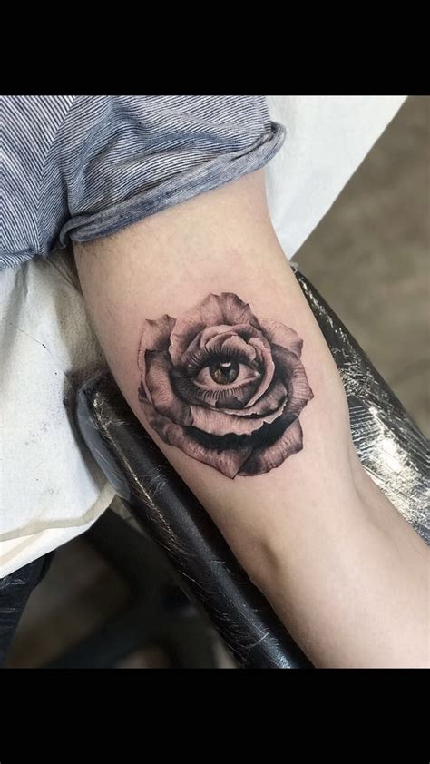 A Black And White Rose Tattoo On The Right Arm With An Eye In It