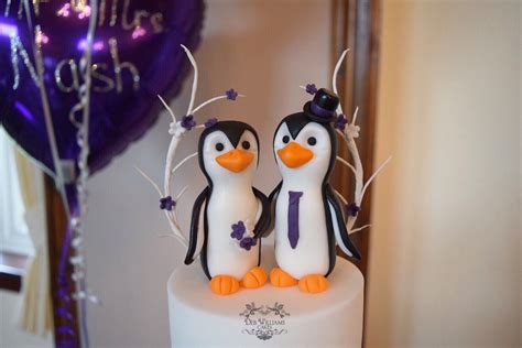 fondant modelled bride and groom penguins as a wedding cake topper by deb williams cakes