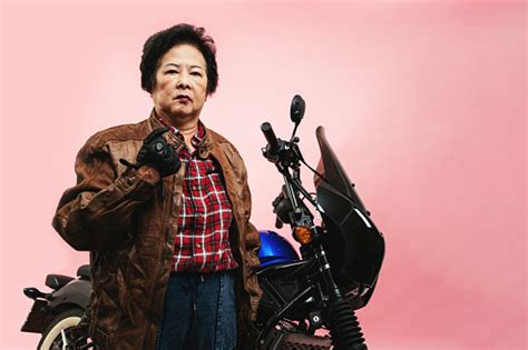 Senior Woman Wearing Leathers With Motorcycle Stock Photo Download