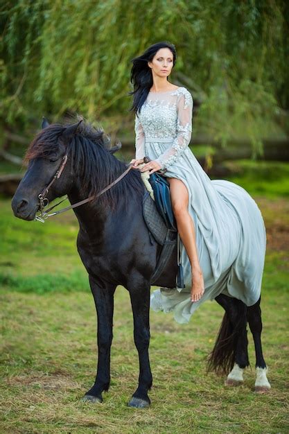 Premium Photo Beautiful Woman In Dress With Black Horse In Nature