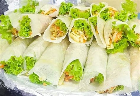 several wraps filled with lettuce carrots and other toppings on a plate