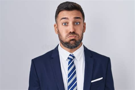 Handsome Hispanic Man Wearing Suit And Tie Puffing Cheeks With Funny Face Stock Photo Image Of