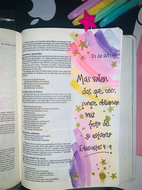 An Open Bible With Writing On It And Colored Pencils Next To The Book S