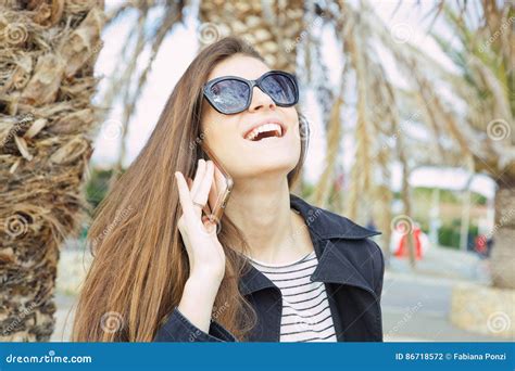 Beautiful Laughing Woman In Sunglasses Talking On Mobile Phone Outside