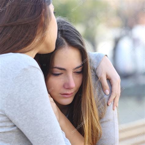 Sad Girl Crying And A Friend Comforting Her Stock Photo