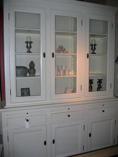 Glue & staple or metal clip assembly. White display cabinet with glass doors