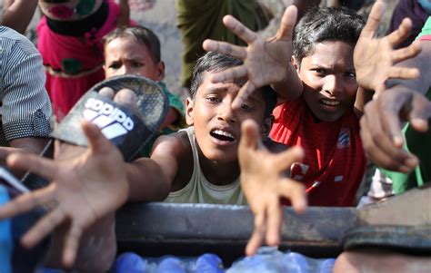 ミャンマーから逃れてきた難民たちが多く集まるバングラデシュ南東部の国境近くで、難民のテントが立ち並ぶ中を、食料の配給を受けた少女が歩いていた＝2017年9月17日、バングラデシュ南東部コックス