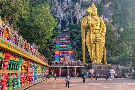 A massive flight of stairs next to giant golden hindu god leading up to what is known as temple cave. 7 Things to Know Before Visiting Batu Caves - Nothing Familiar