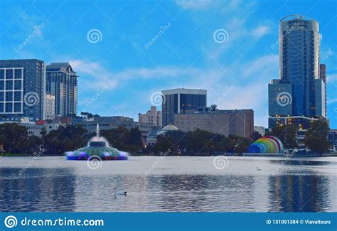 City Skyline And Colorful Water Fountain At Sunset In Lake Eola Park