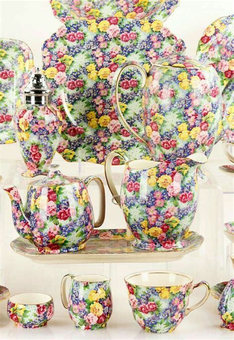 A Table Topped With Lots Of Colorful Cups And Saucers Covered In Floral
