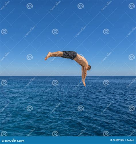 Fly After Jump Man Jumping In Blue Sea Water For Dive Stock Photo