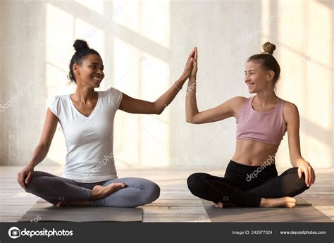 Toned Female Yogi Give High Five Practicing Yoga Together Stock Photo