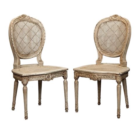 Finished in antique white with a distressed effect. Six French Painted and Caned Oval Back Chairs at 1stdibs