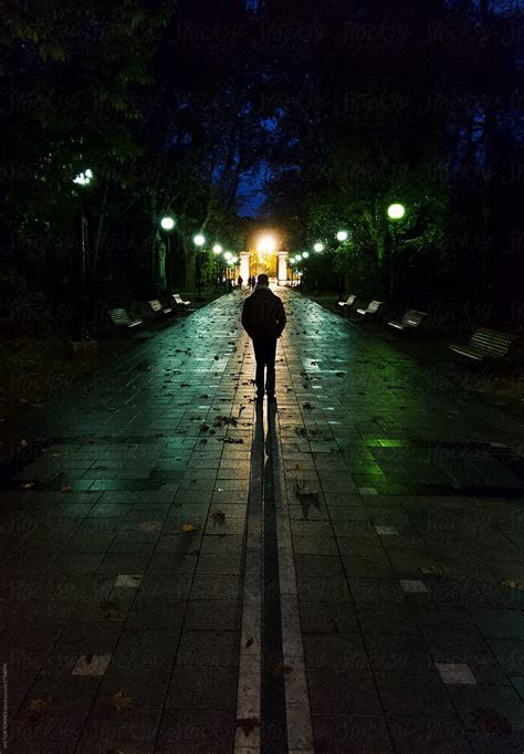 Man Walking Alone Throug A Dark Street At Night By Victor Torres