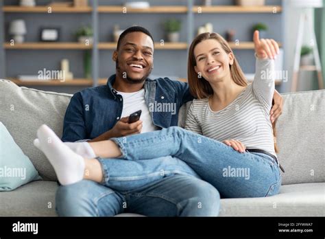 Happy Interracial Lovers Spending Time In Living Room Together