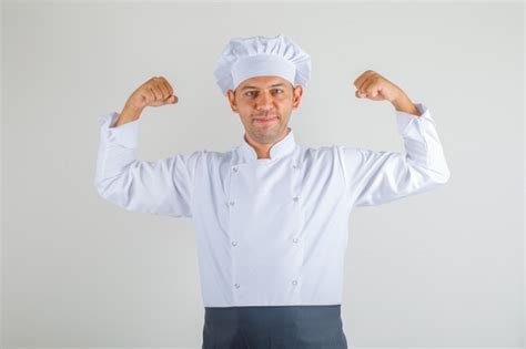 Free Photo Male Chef Showing Flexing Muscles And Smiling Away In Uniform Apron And Hat And