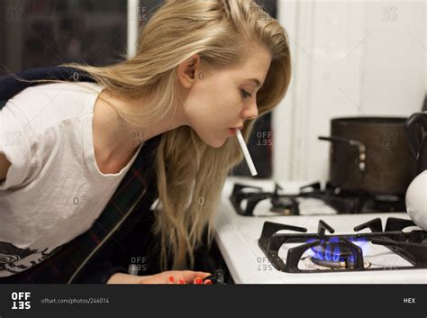 Young Woman Lighting A Cigarette With Stove Stock Photo Offset