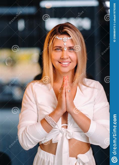 Portrait Of A Smiling Girl In A White Dress With Her Palms Clasped In Front Of Her Stock Image