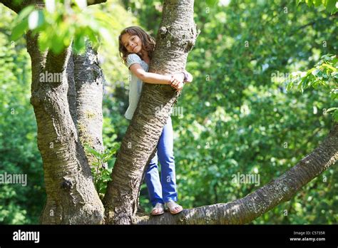 Smiling Girl Climbing Tree Outdoors Stock Photo Alamy