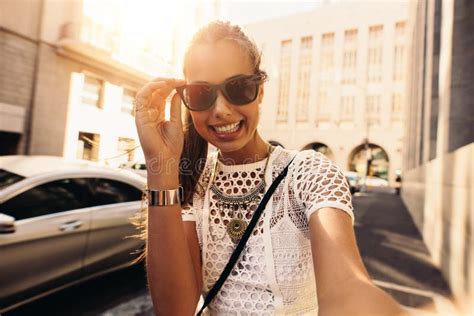 Young Woman Taking Selfie In A Street Surrounded By Buildings Stock