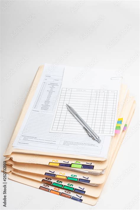A Stack Of Medical Records In Folders With Color Coded And Numbered
