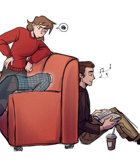 A Woman Sitting On Top Of A Red Couch Next To A Man Who Is Reading