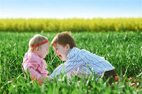 Little Children Boy And Girl Play On Green Grass Stock Photo Image Of