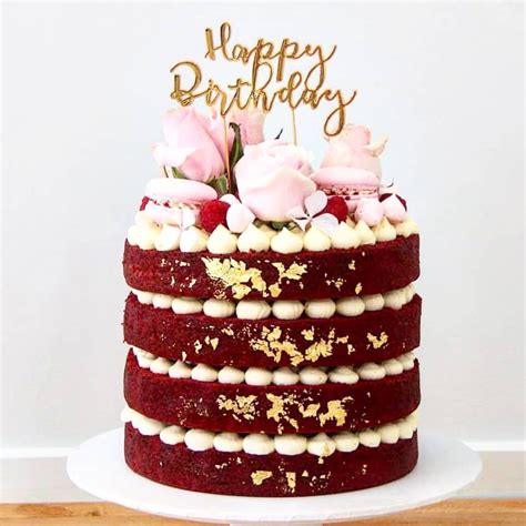 A Red Velvet Cake With White Frosting And Flowers On Top