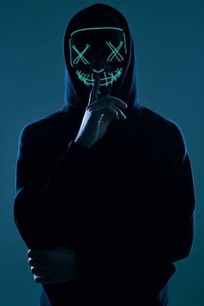 Anonymous Man In Black Hoodie Hiding His Face Behind A Neon Mask Premium Photo